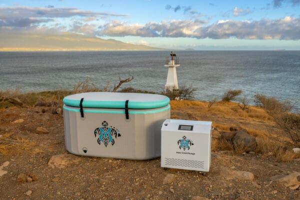 A cooler sitting on top of a beach next to the ocean.